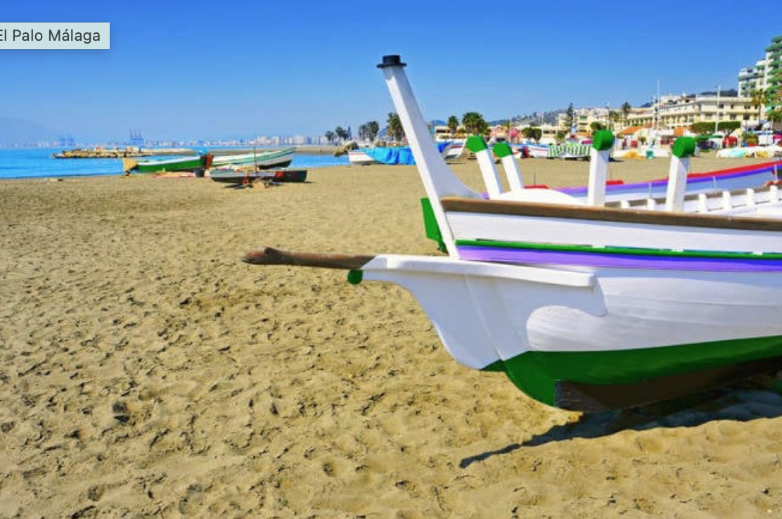 Tradicional barca de jábega de madera varada en la arena de la playa de El Palo, Málaga
