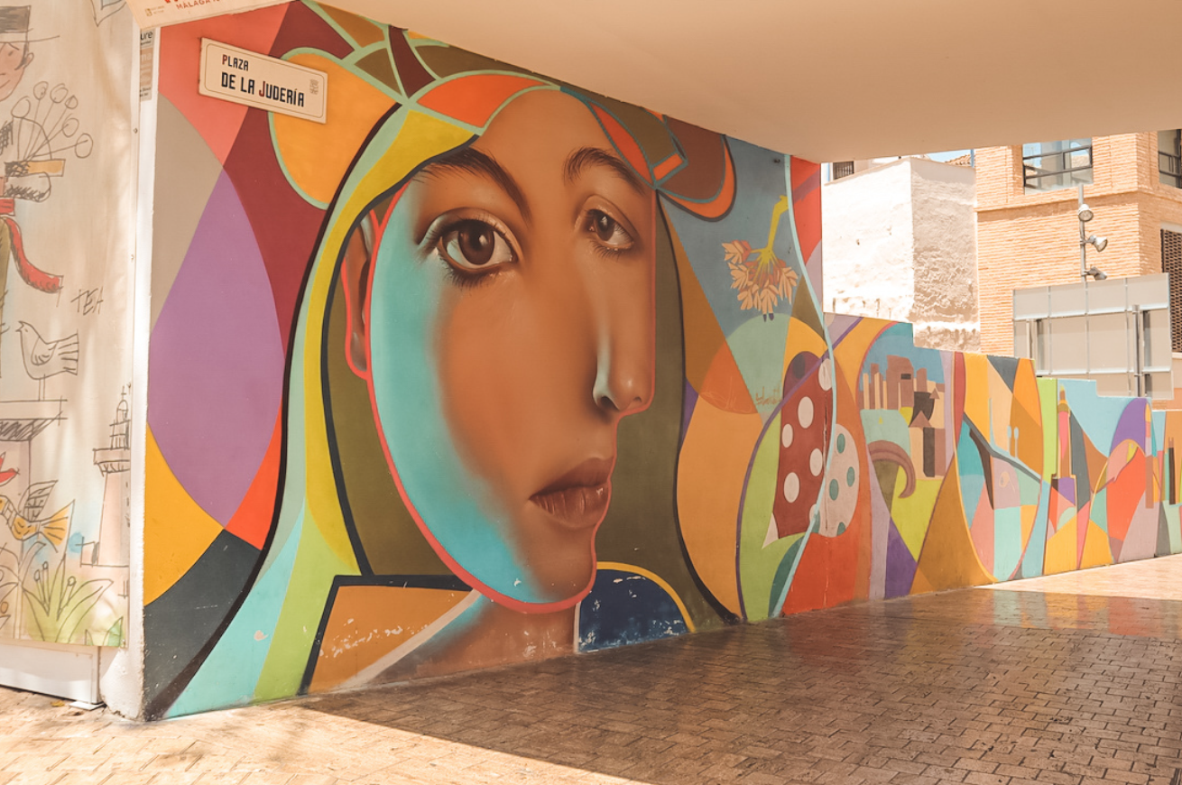 Mural colorido a gran escala en una fachada del barrio Soho de Málaga